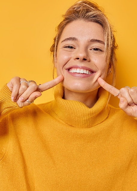 Portrait of smiling woman pointing at her teeth