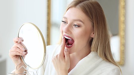 Patient in Tampa with dental implants checking their mouth