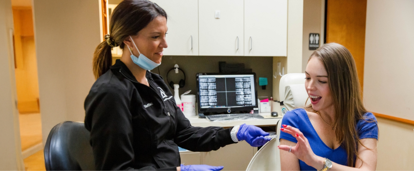 Tampa dentist and team member talking to patient in dental chair