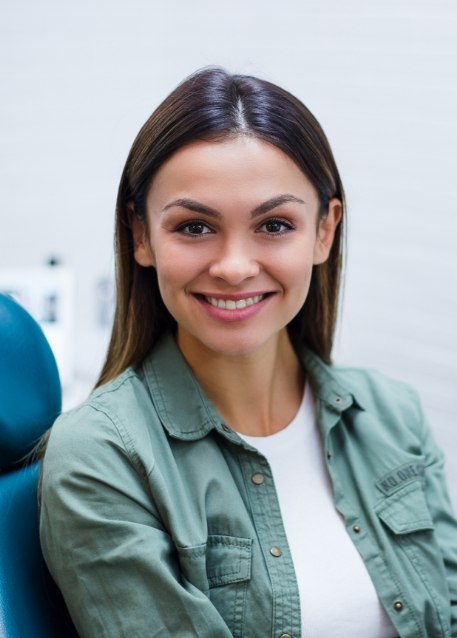 Woman smiling in dental chair after cosmetic dentistry in Tampa