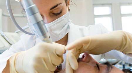 Dentist with a tool in a patient’s mouth