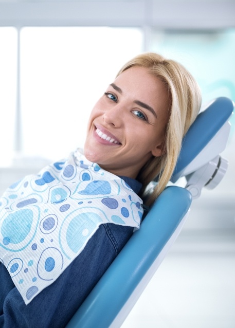 Smiling woman in dental chair before dental exam and cleaning in Tampa