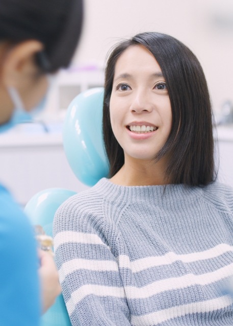 Woman in dental chair listening to her dentist talk