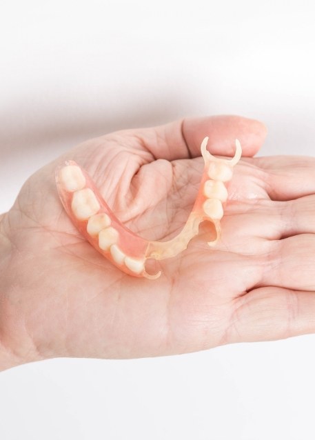Hand holding a partial denture in Tampa