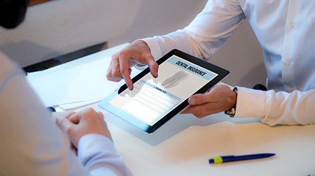 An insurance agent discussing dental insurance with a patient