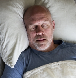 Older man sleeping on his back with his mouth open