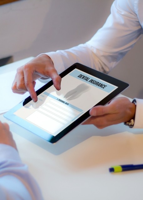 Two people looking at dental insurance forms on tablet