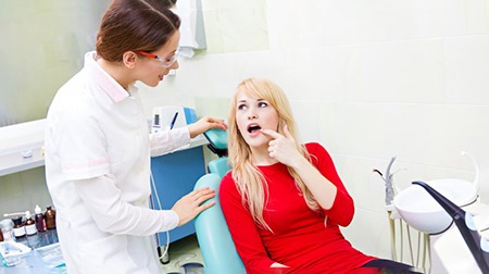 Patient pointing out hurting tooth to dentist