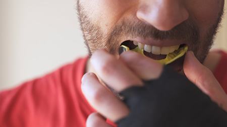 Closeup of athlete inserting a mouthguard