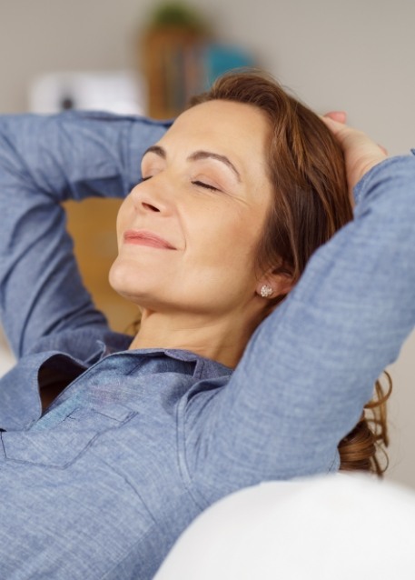 Woman relaxing in chair with her hands behind her head
